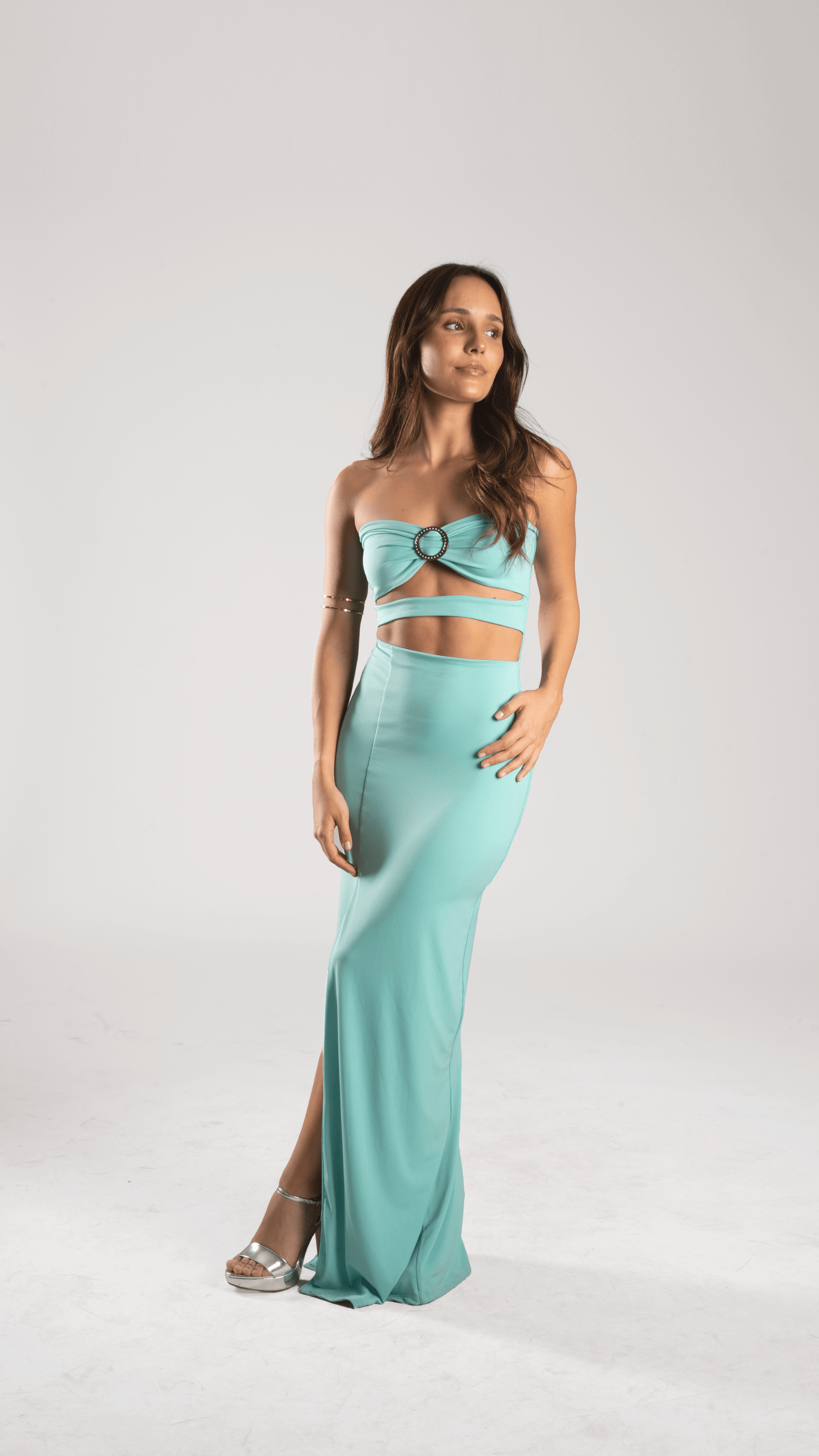 Modelo vistiendo vestido de fiesta turquesa con corte sirena y tajo, ideal para ocasiones especiales.