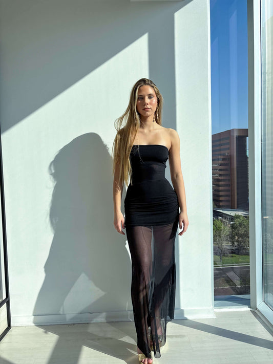 Strapless mermaid party dress model showcasing elegant design with transparent skirt in bright indoor setting.