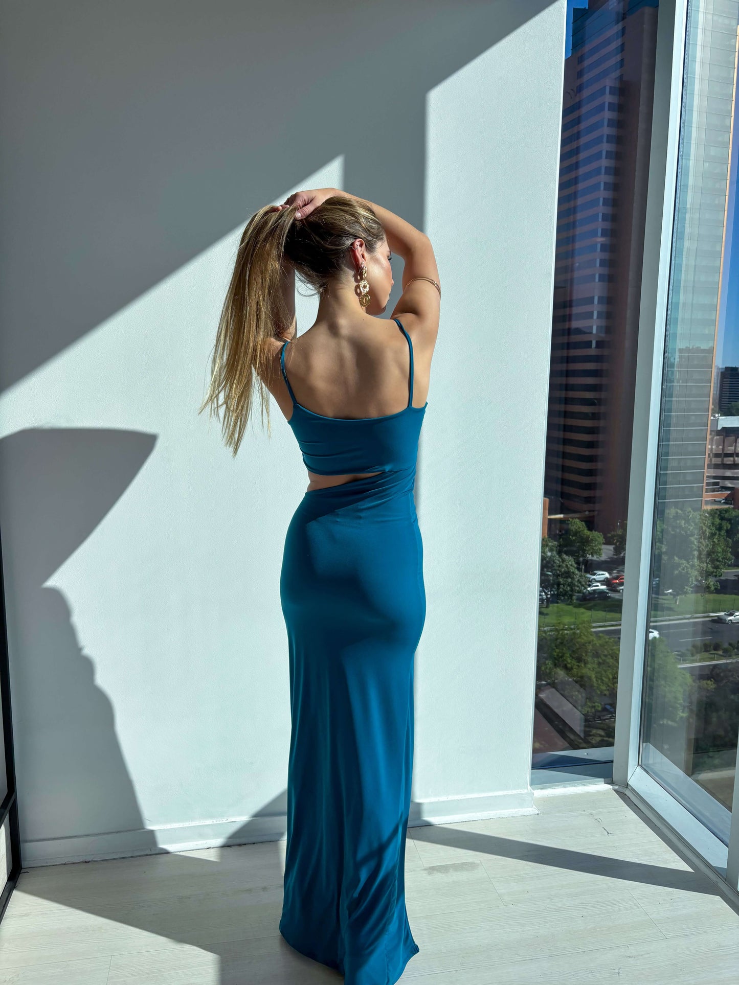 Modelo luciendo el Vestido Nicoletta Petróleo, elegante y moderno, con corte sirena y espalda descubierta.