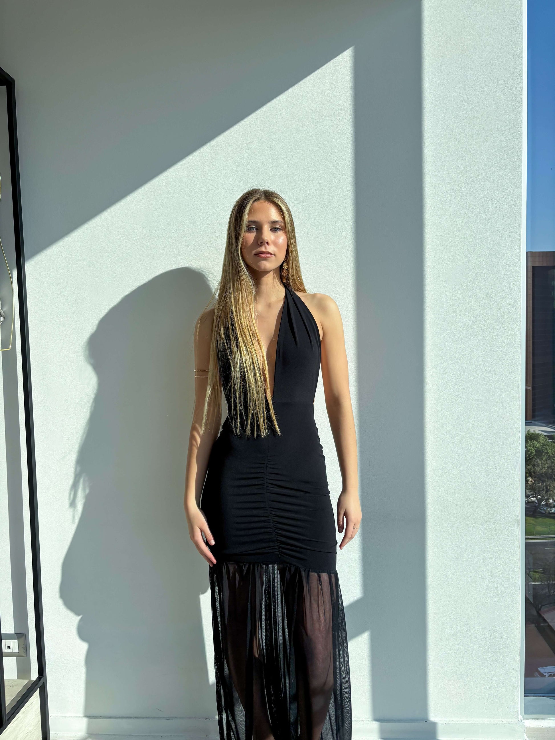 Vestido Simona Negro elegante en modelo, resaltando su diseño ajustable y falda transparente.