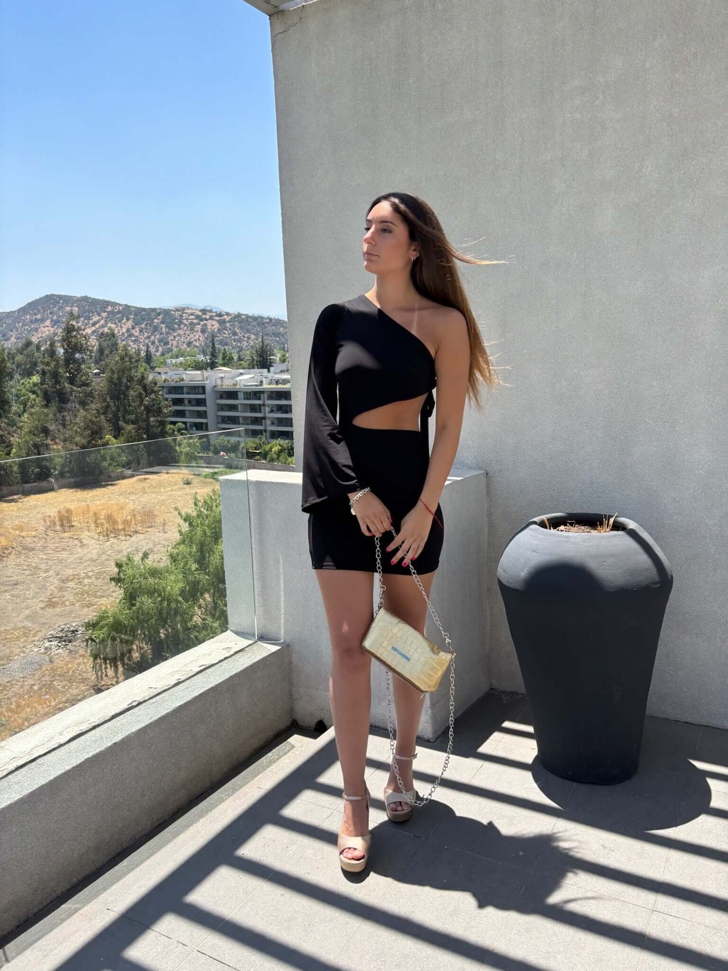 Mujer luciendo vestido largo elegante negro con abertura, ideal para gala y graduación. Envío a todo Chile.