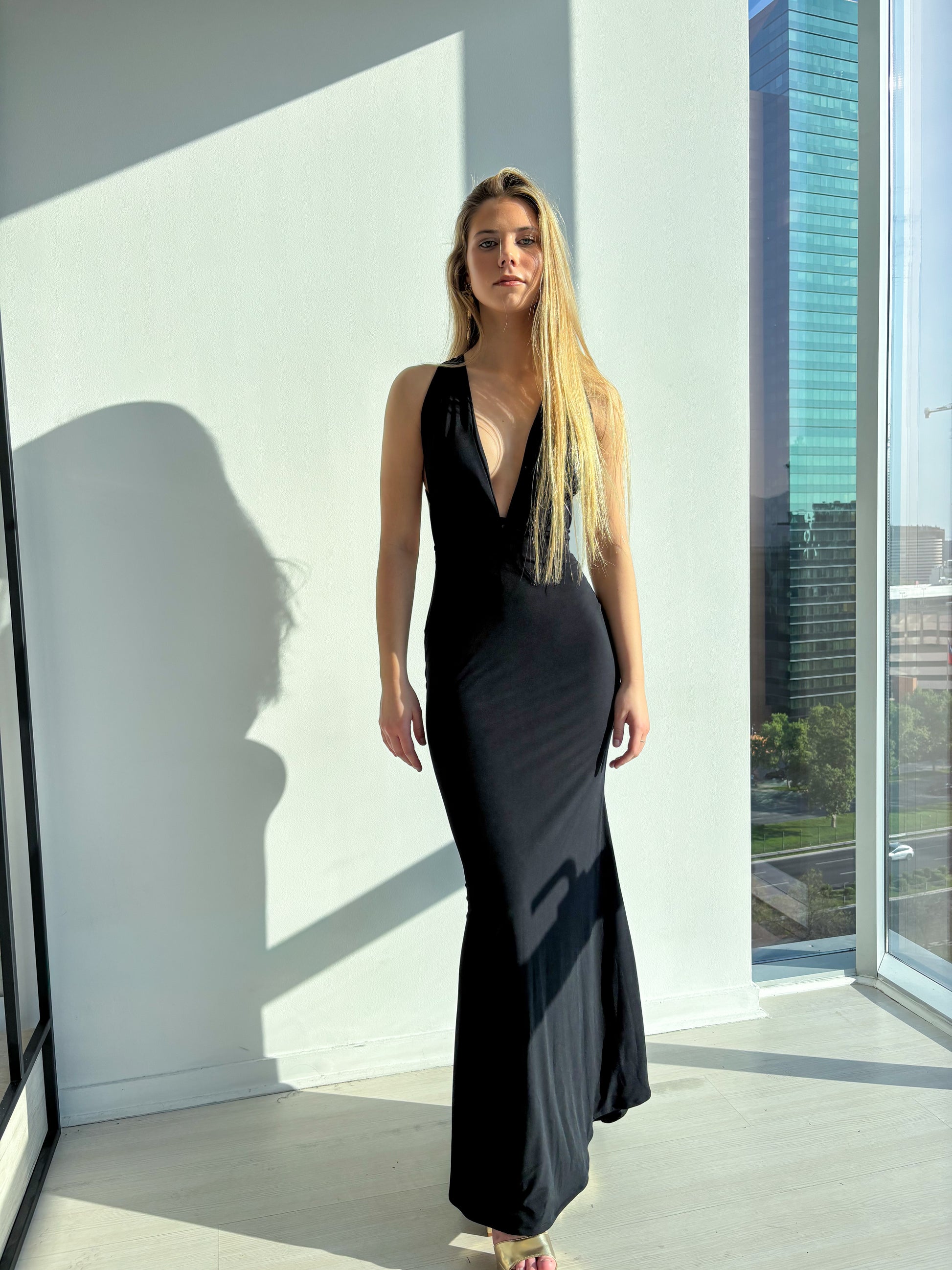 Vestido Milán Negro modelo en evento formal con corte sirena y espalda descubierta, elegante y moderno.